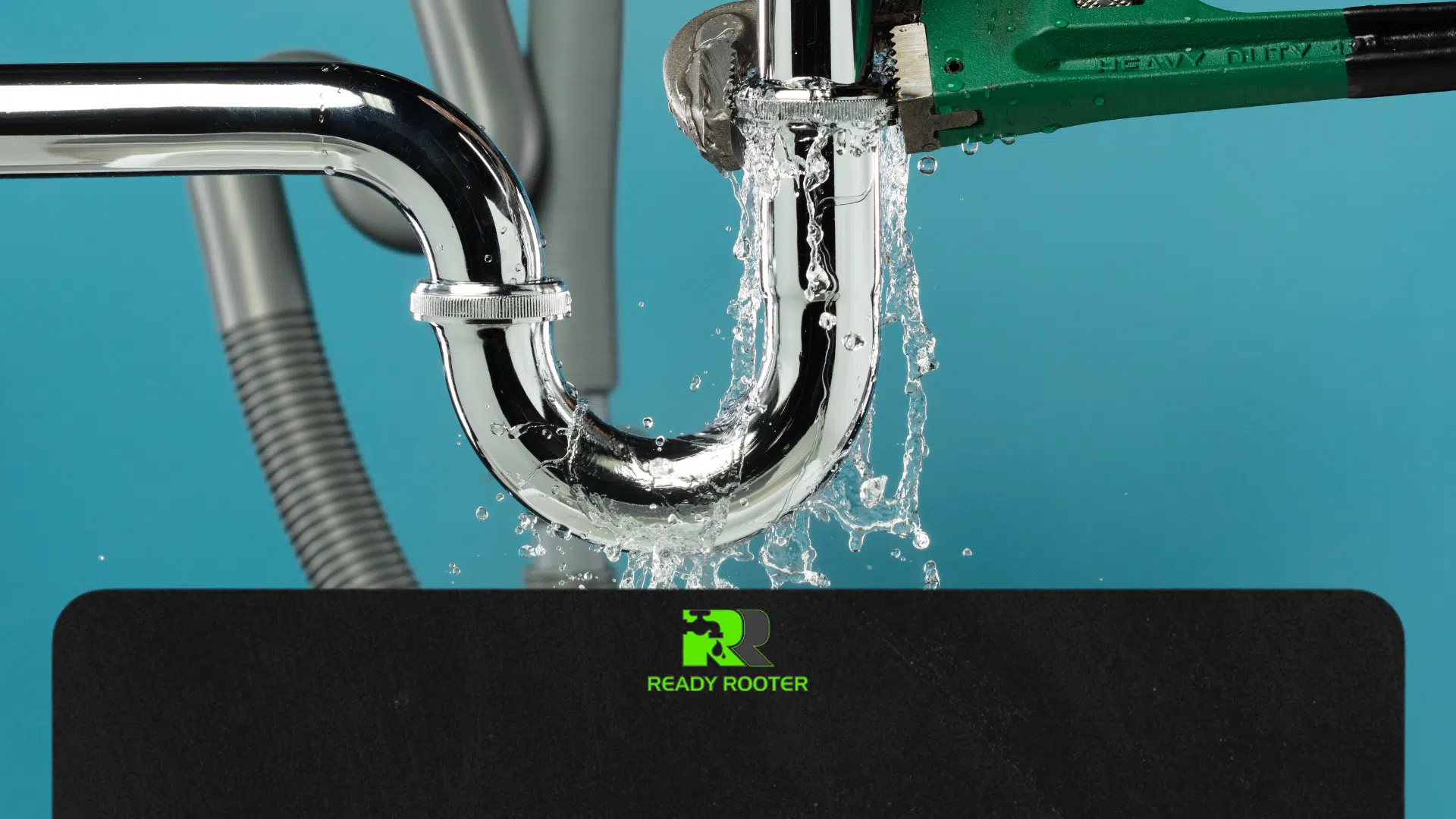 Close-up of a chrome sink trap (P-trap) with a pipe burst and water spraying out, illustrating a plumbing emergency.