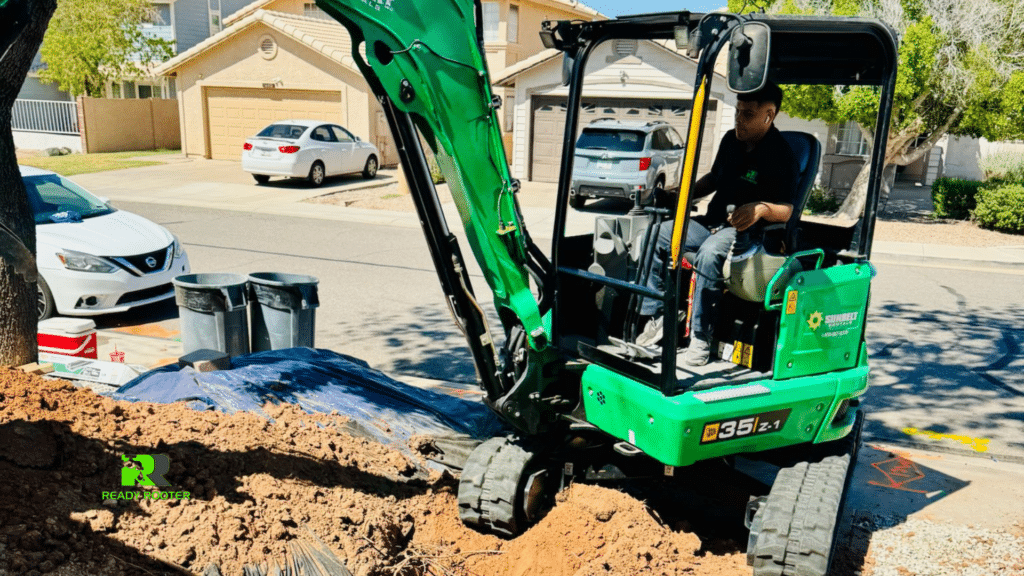 Compact excavator digging a trench in a residential driveway
