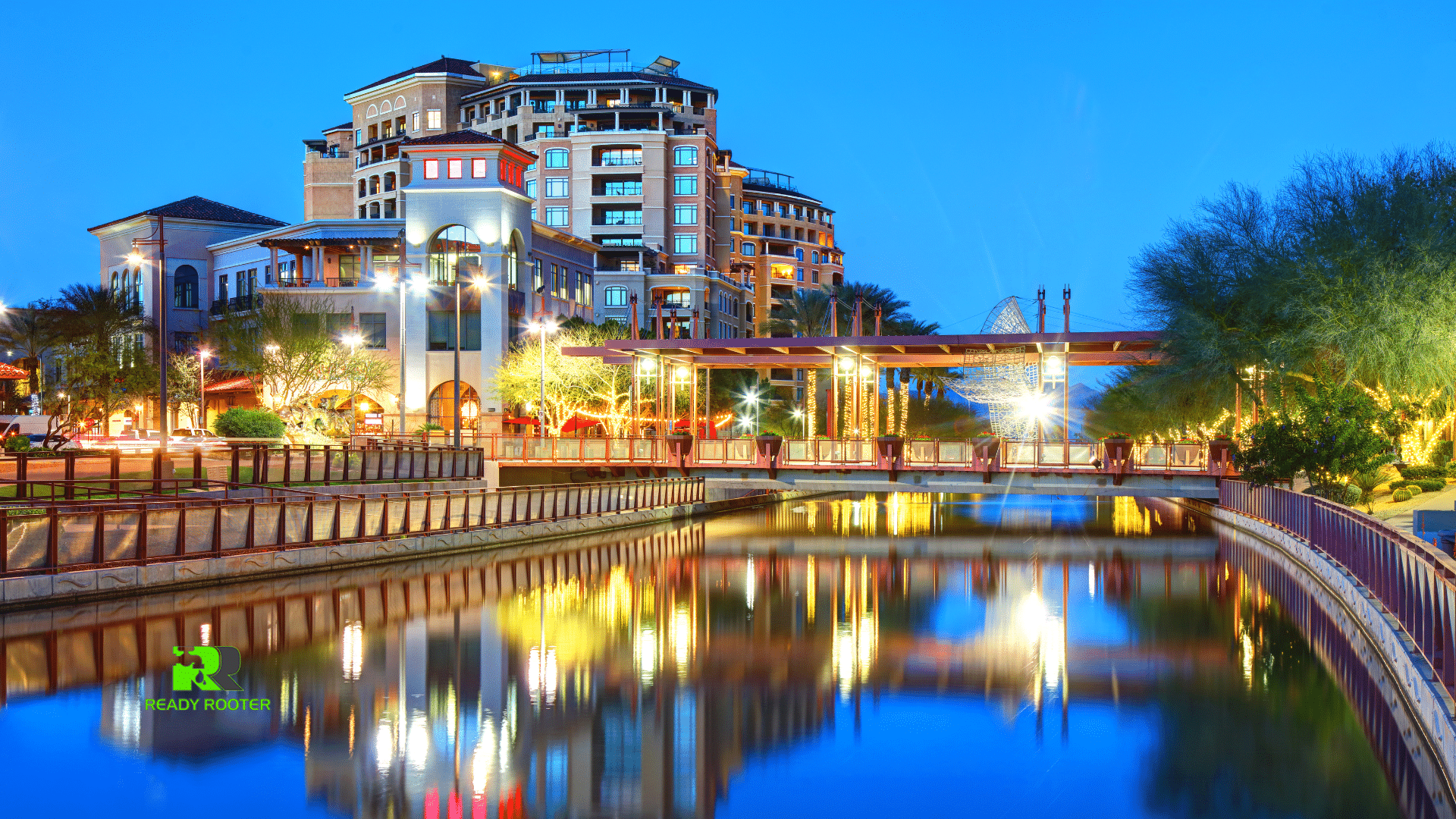 Scottsdale waterfront buildings lit at dusk reflecting in the Arizona Canal